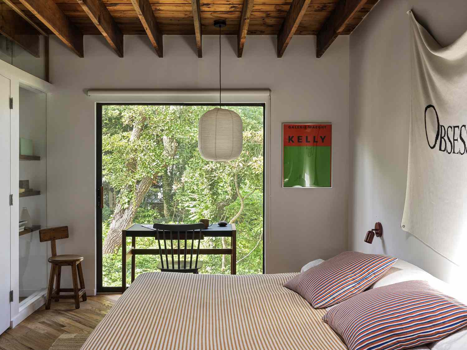 bedroom with wood beam ceiling and paper pendant light