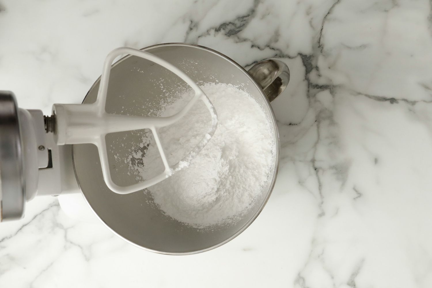 overhead view of a mixing bowl with powdered sugar 