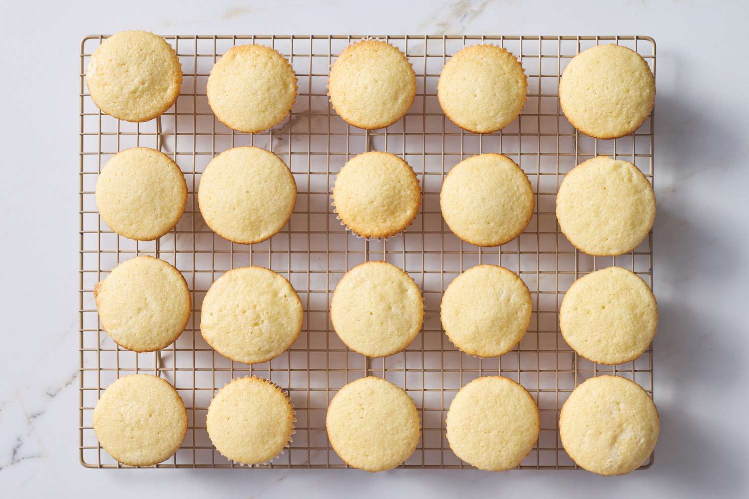 Fresh baked cupcakes on a cooling rack arranged evenly