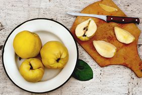 plate of quince and cutting board with cut quince and knife