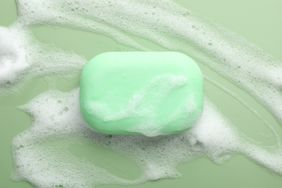 Bar of soap with foam on a green surface