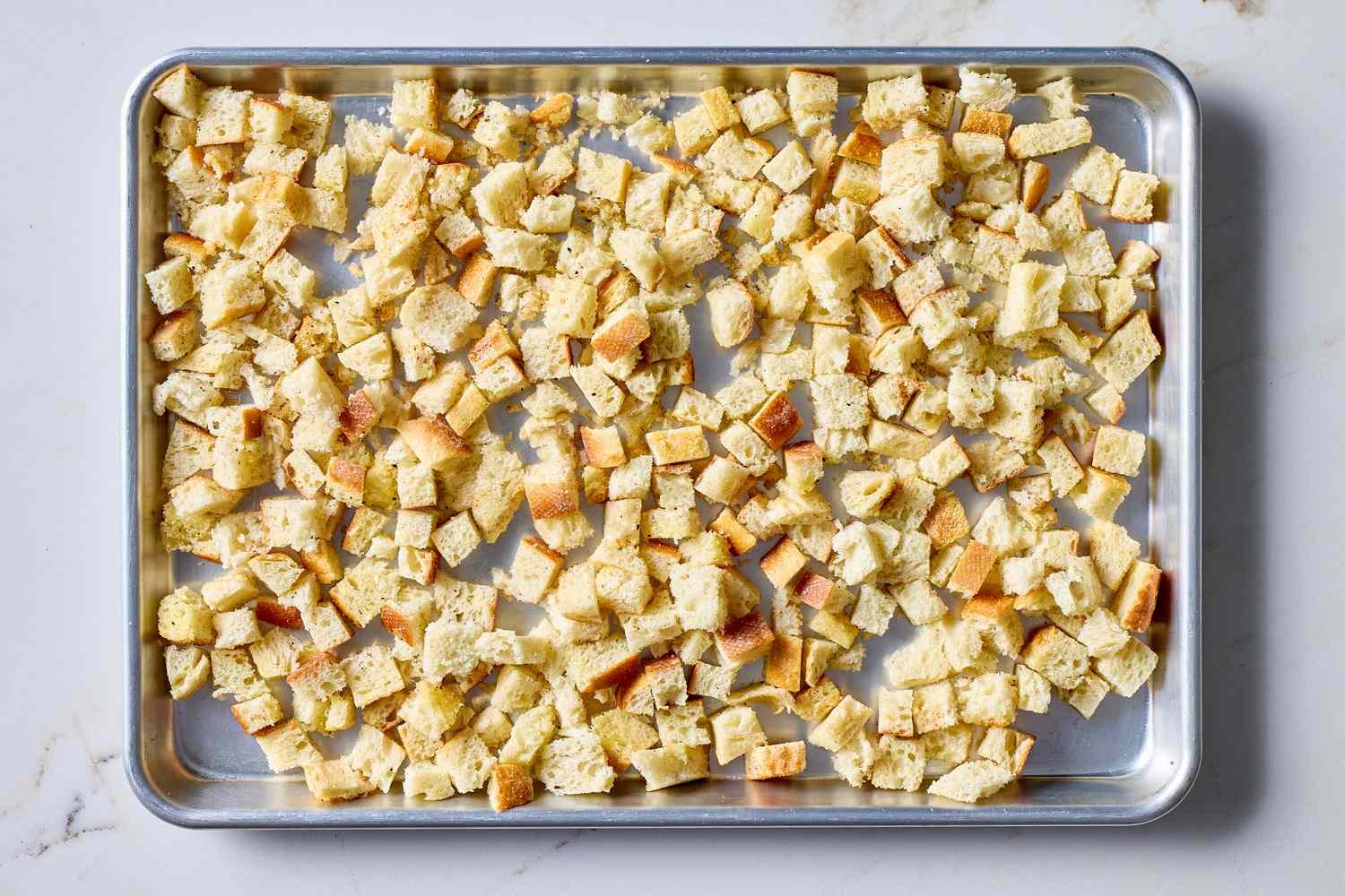 Cubed bread on a baking sheet prepared for making croutons or similar use