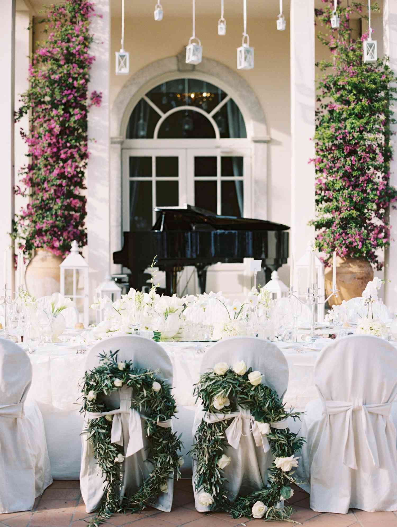 reception chairs adorned with white flowers and greenery