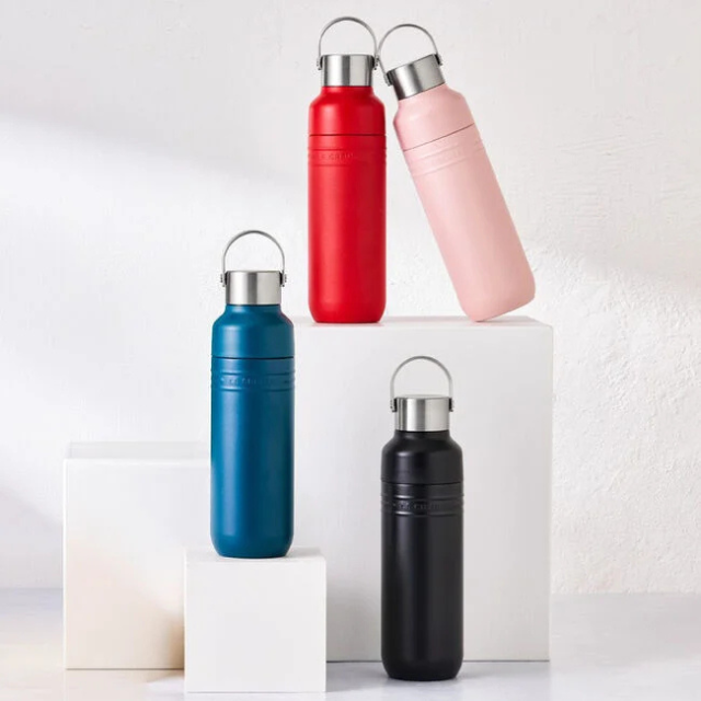 Four stainless steel water bottles arranged on geometric shelves