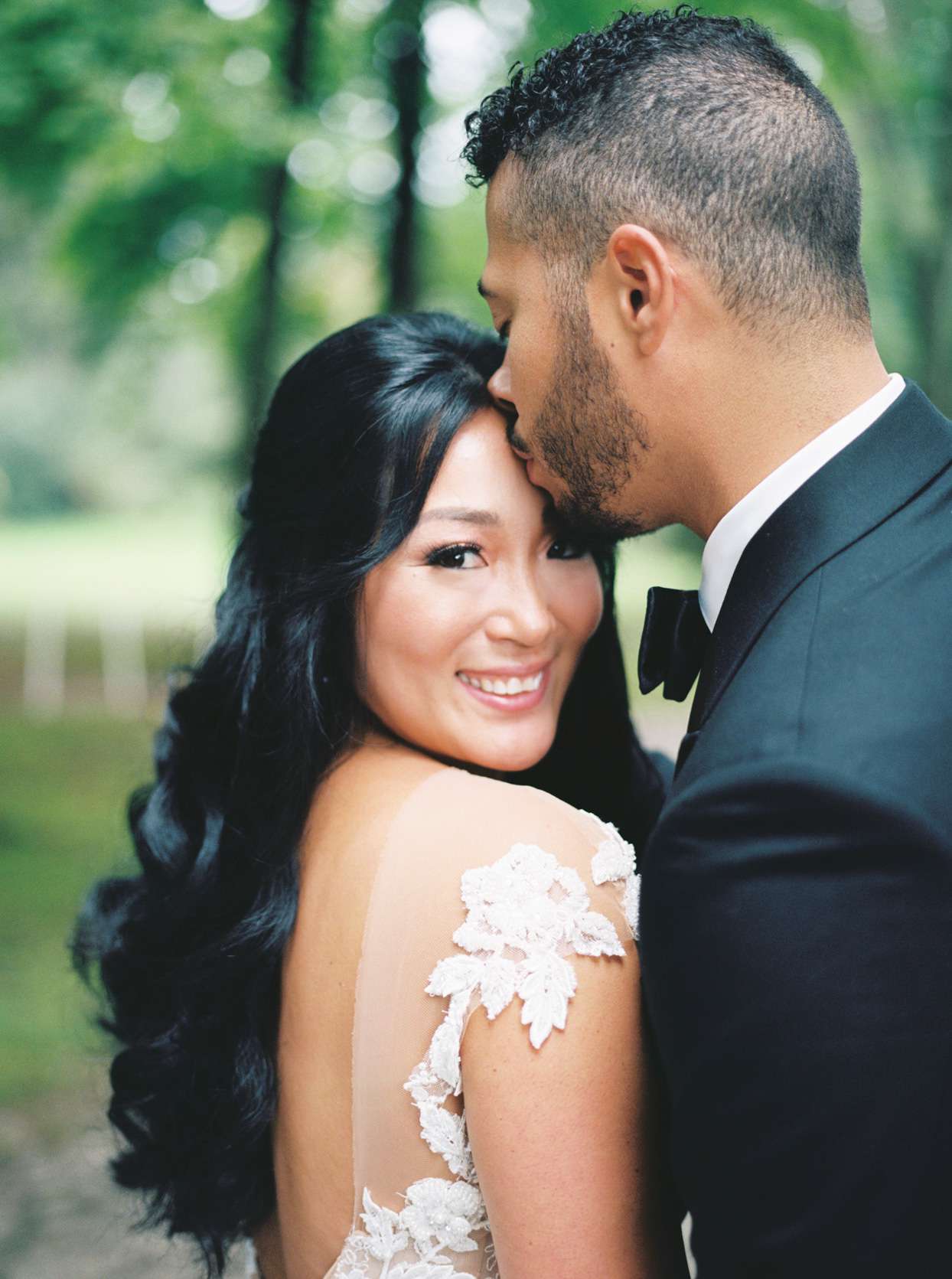 groom kissing bride on forehead