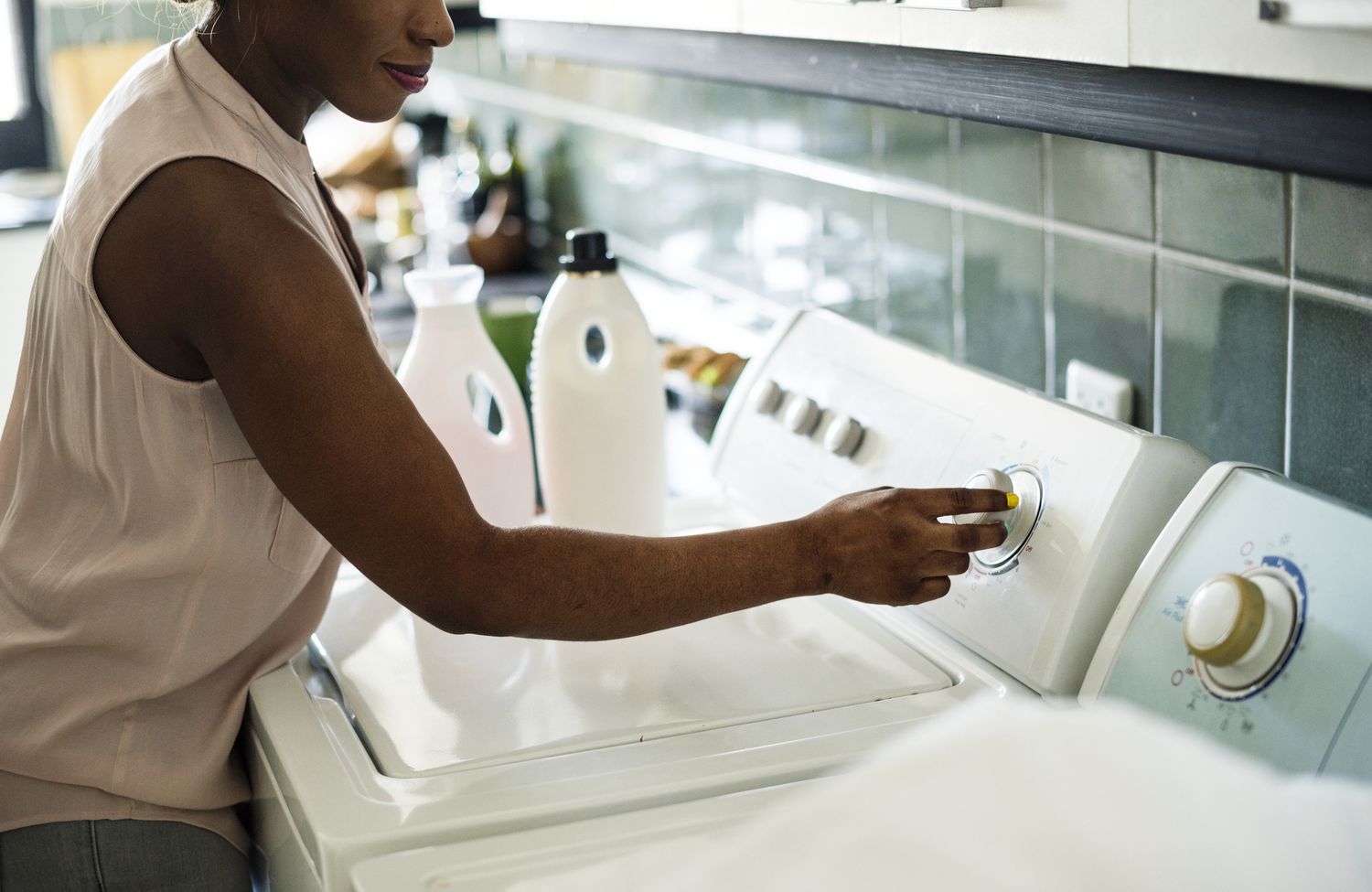 Woman doing laundry using top-loading washing machine