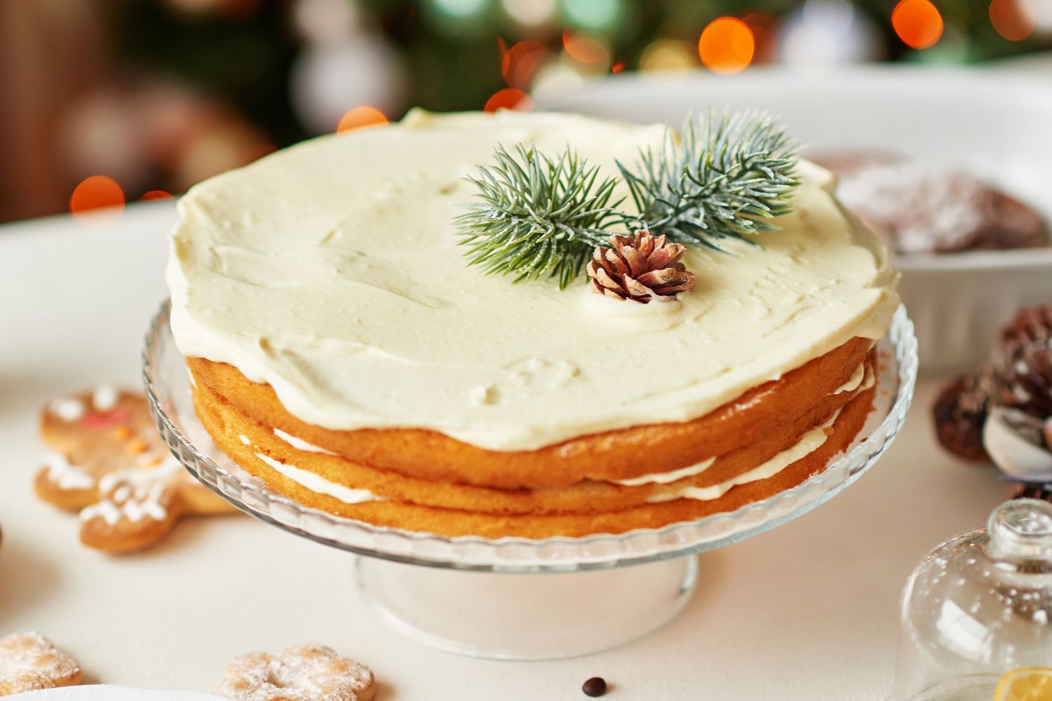 Layered homemade cake topped with cream and a pine cone decoration