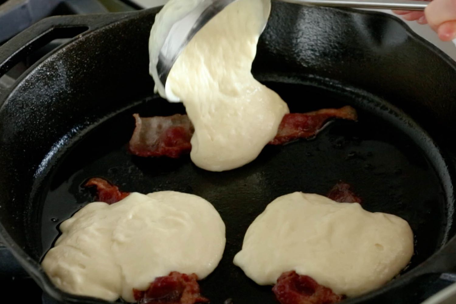adding pancake batter to slices of bacon