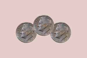 three 1975 dimes on a pale pink background