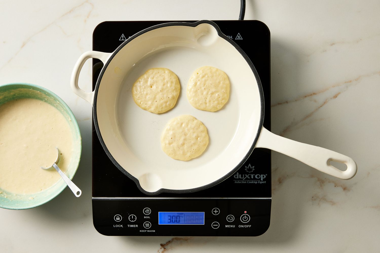 Silver dollar pancakes bubbling on skillet in pan