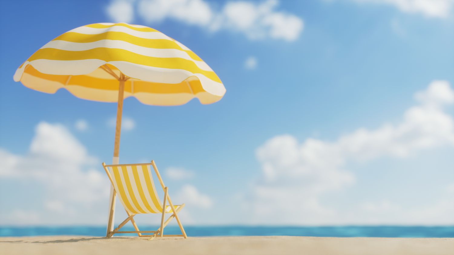 A beach chair and umbrella on a sandy beach with the ocean in the background