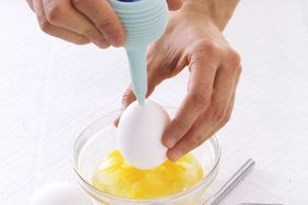 blowing out egg yolk into bowl