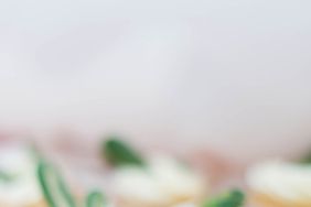 vanilla cupcakes with white frosting and green leaves