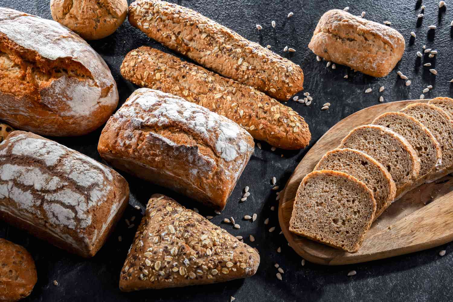 different loaves of bread on dark surface