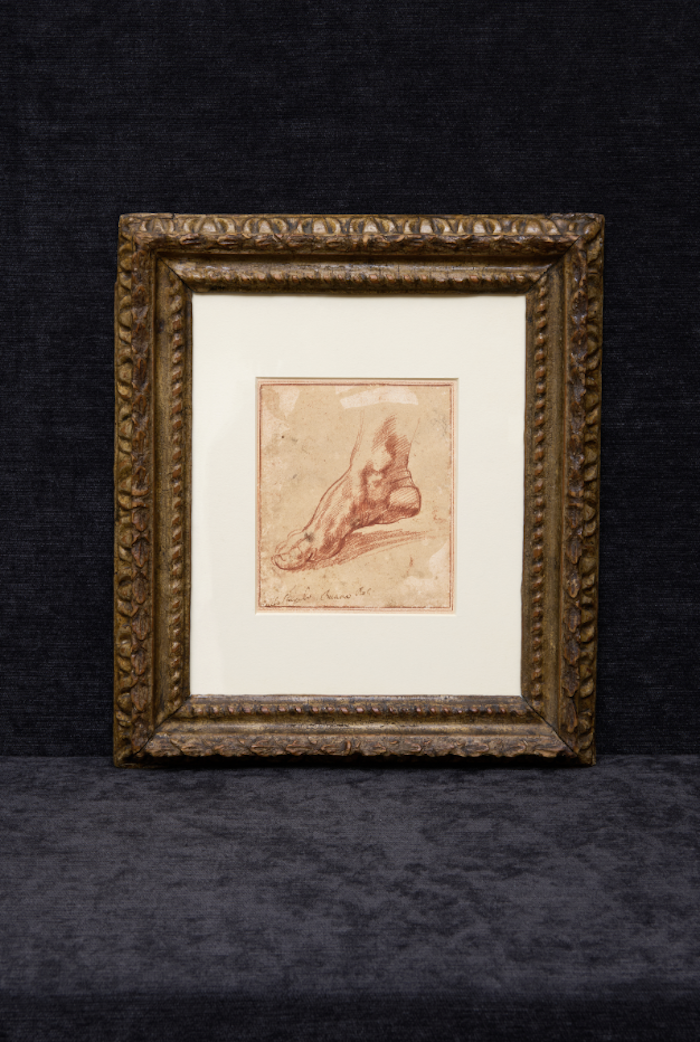 Framed drawing depicting a sketch of a reclining figure displayed on a dark background