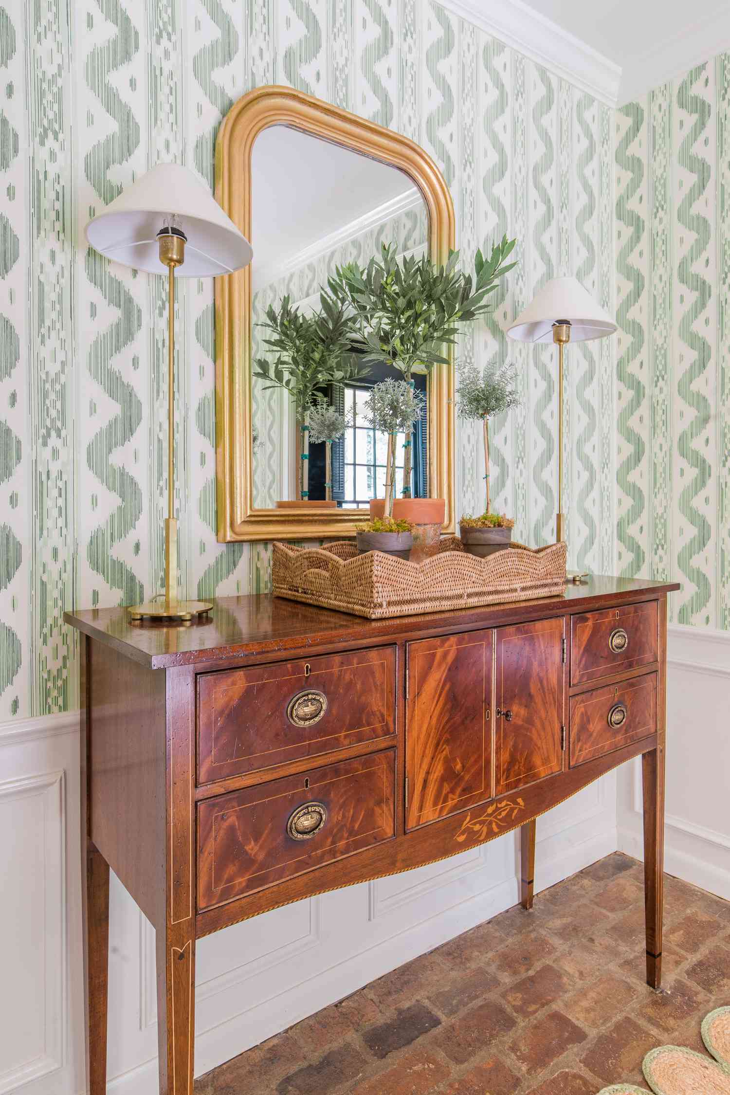Hallway with patterned wallpaper and gold mirror
