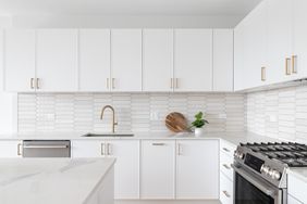 Modern kitchen with laminate cabinets a gas stove a marble countertop and a decorative backsplash