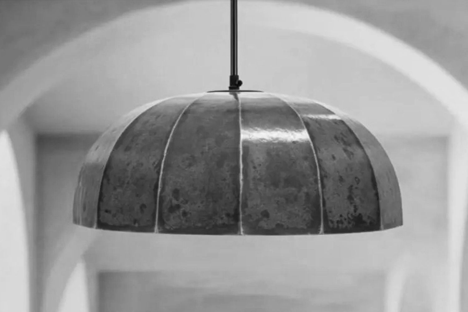 A metal domeshaped pendant light hanging from a ceiling