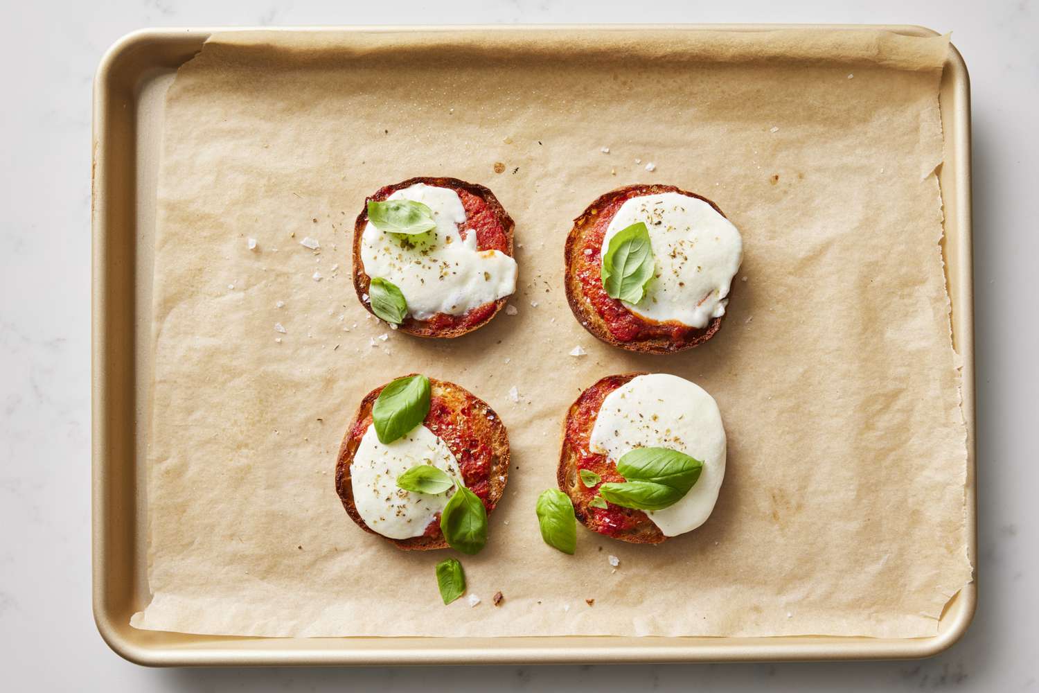 English muffin pizza snacks on baking sheet