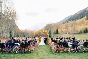 outdoor wedding ceremony with colorful floral archway