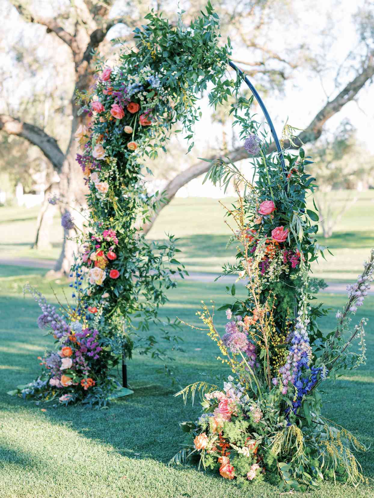 outdoor arch ceremony setup with colorful flowers