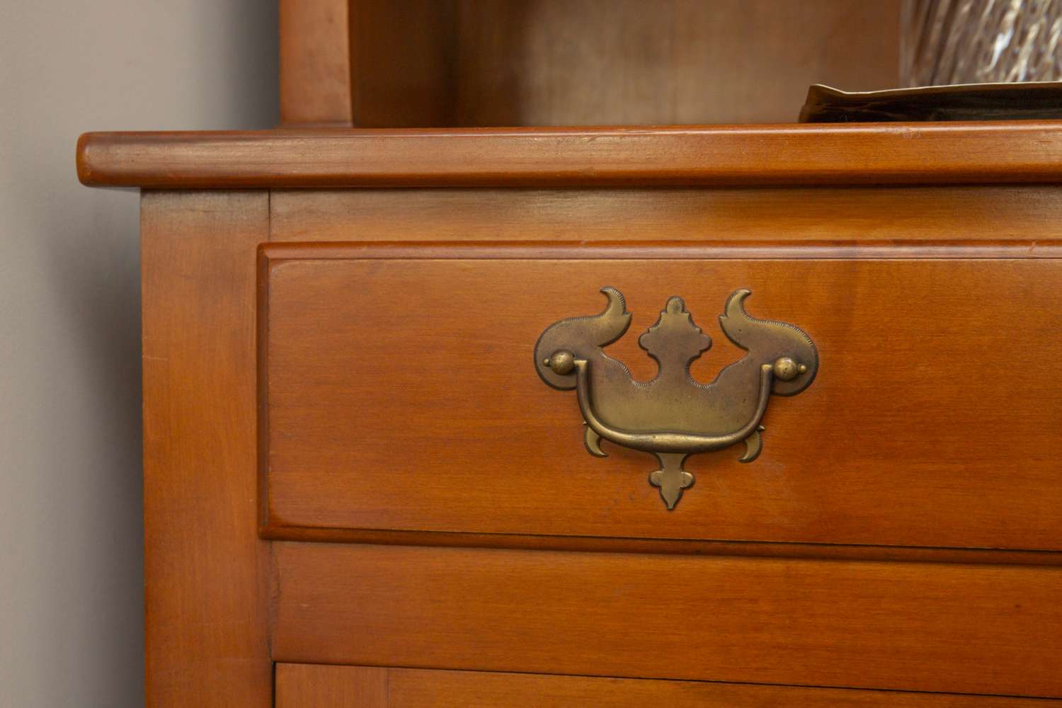 Closeup of a wooden drawer with a decorative metal handle part of a piece of furniture