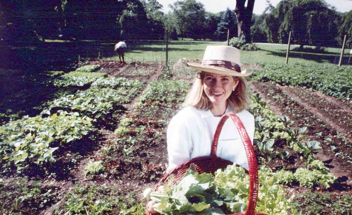 decorvow holding a basket of fresh vegetables in a garden