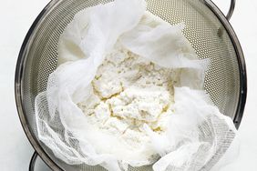 homemade ricotta draining in sieve