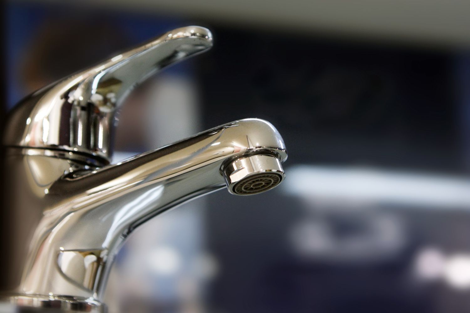 Closeup of a polished metal faucet with a blurred background