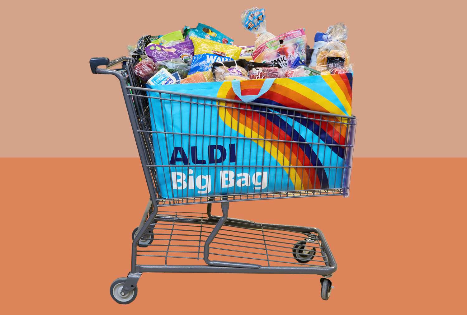 A shopping cart filled with groceries and an Aldibranded reusable bag with colorful stripes