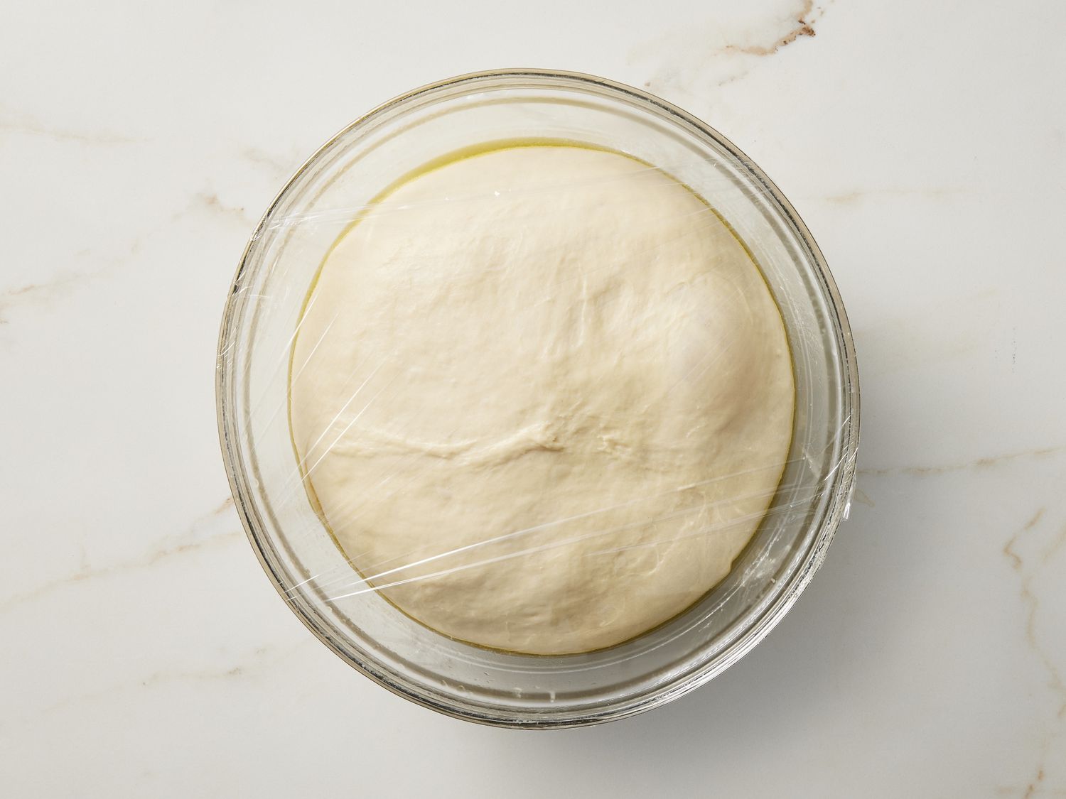 Risen dough in glass bowl 