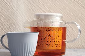 glass teapot with tea and ceramic mug