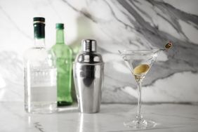 Gin cocktail with gin bottles in background