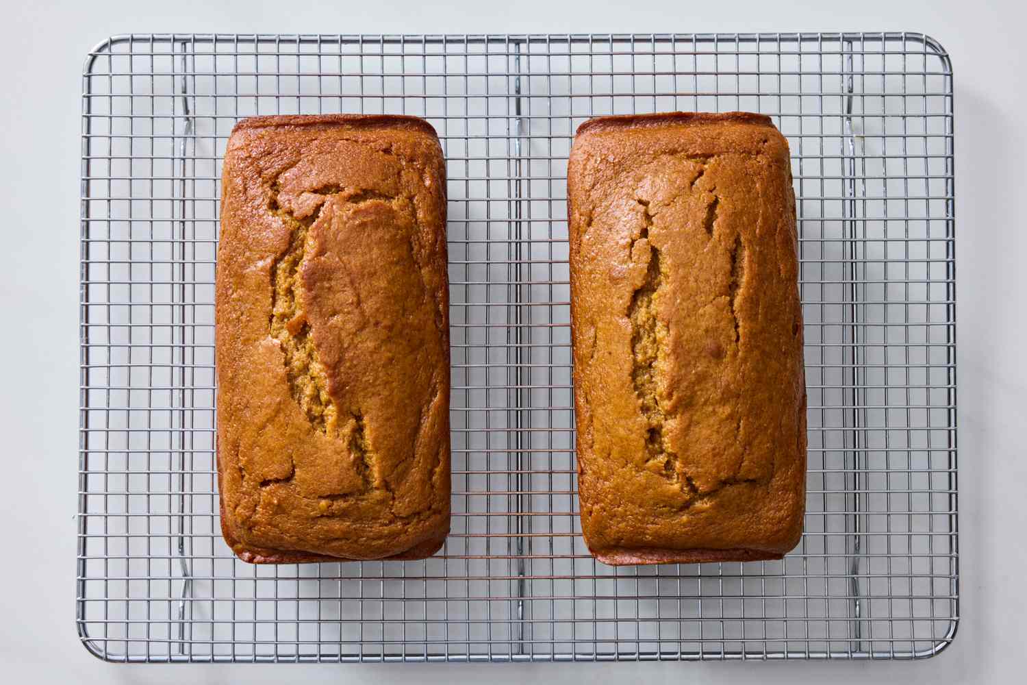 Two loaves of bread on a cooling rack