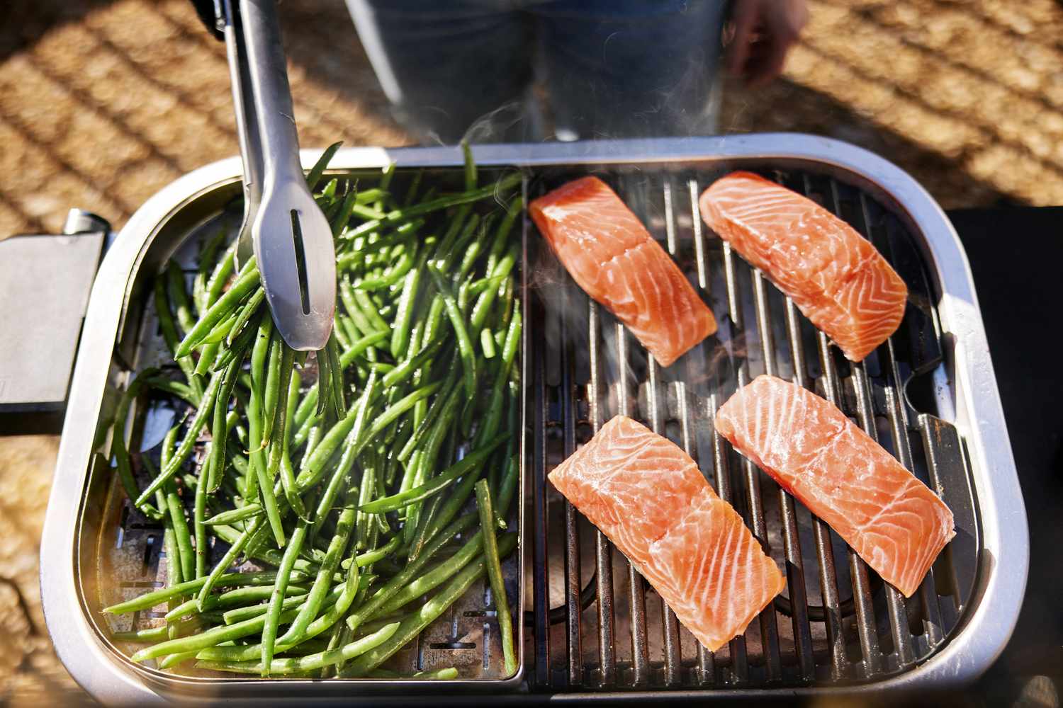 salmon and green beans cooking on an electric grill outdoors