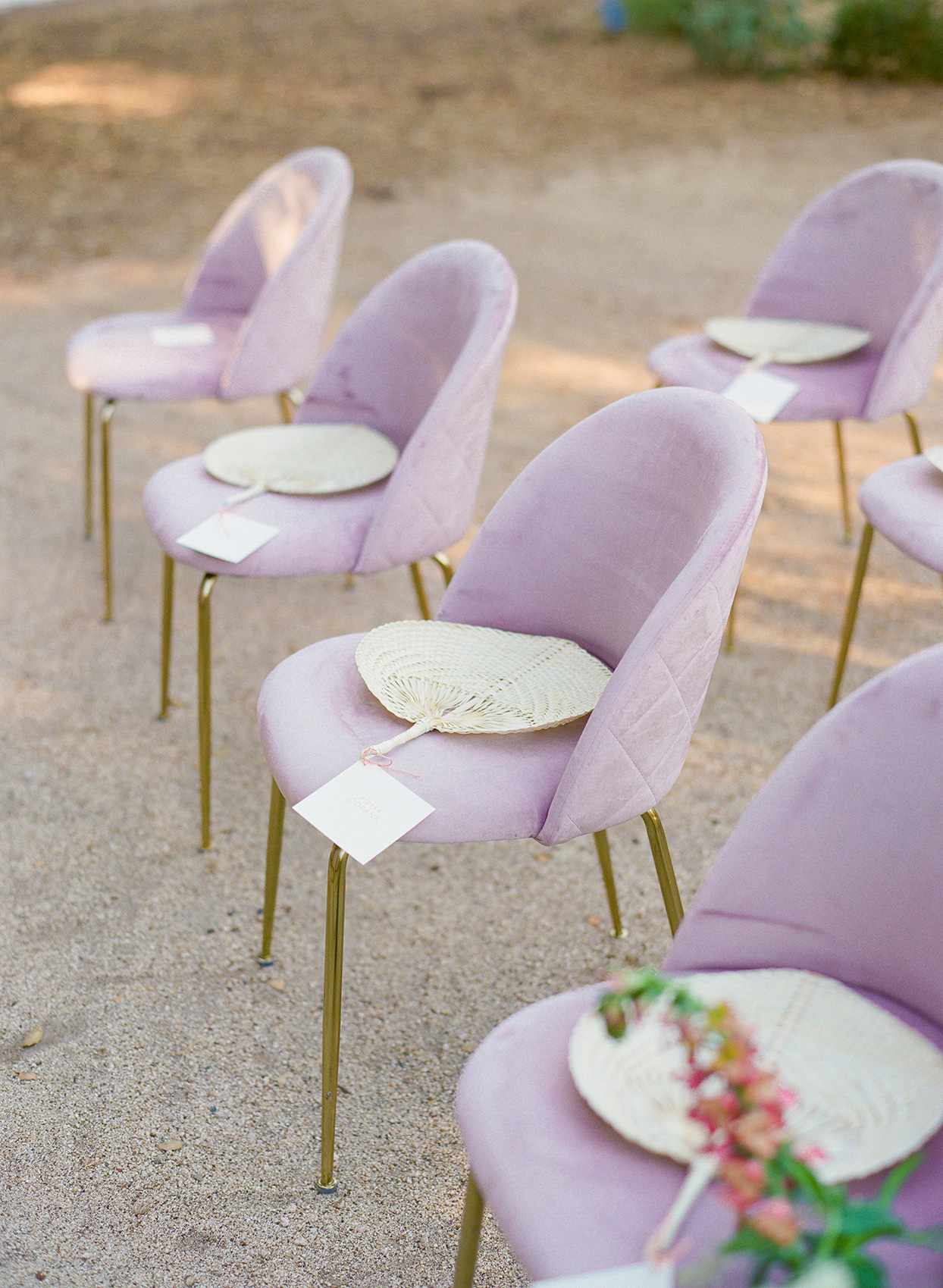 purple tufted wedding chairs with gold legs and fan on the seats