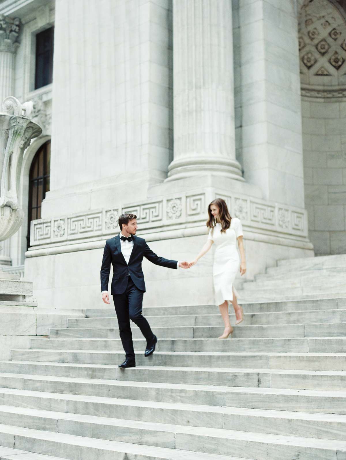 city hall wedding groom holding brides hand descending stairs