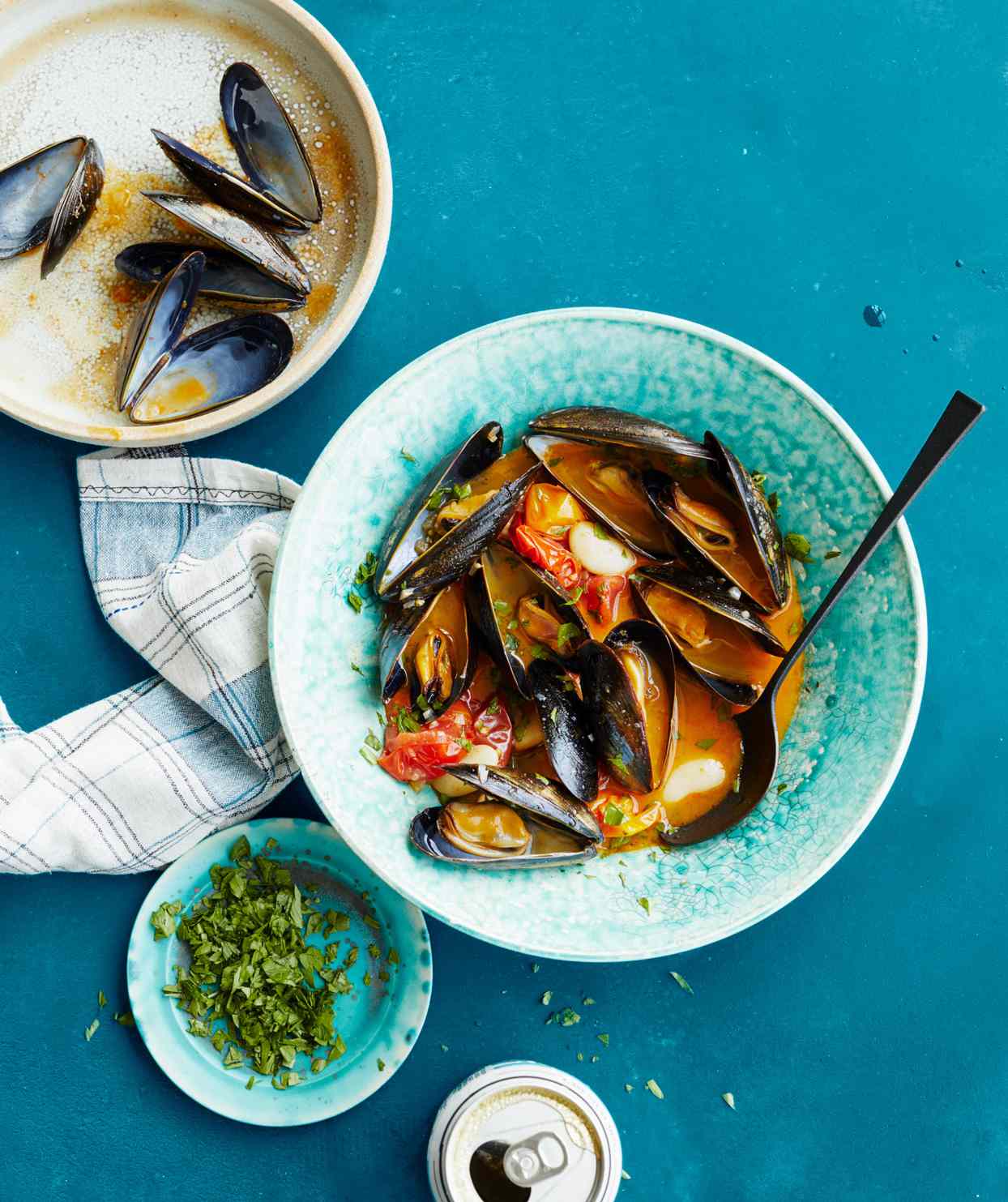 drunken mussels with chorizo and white beans topped with parsley leaves