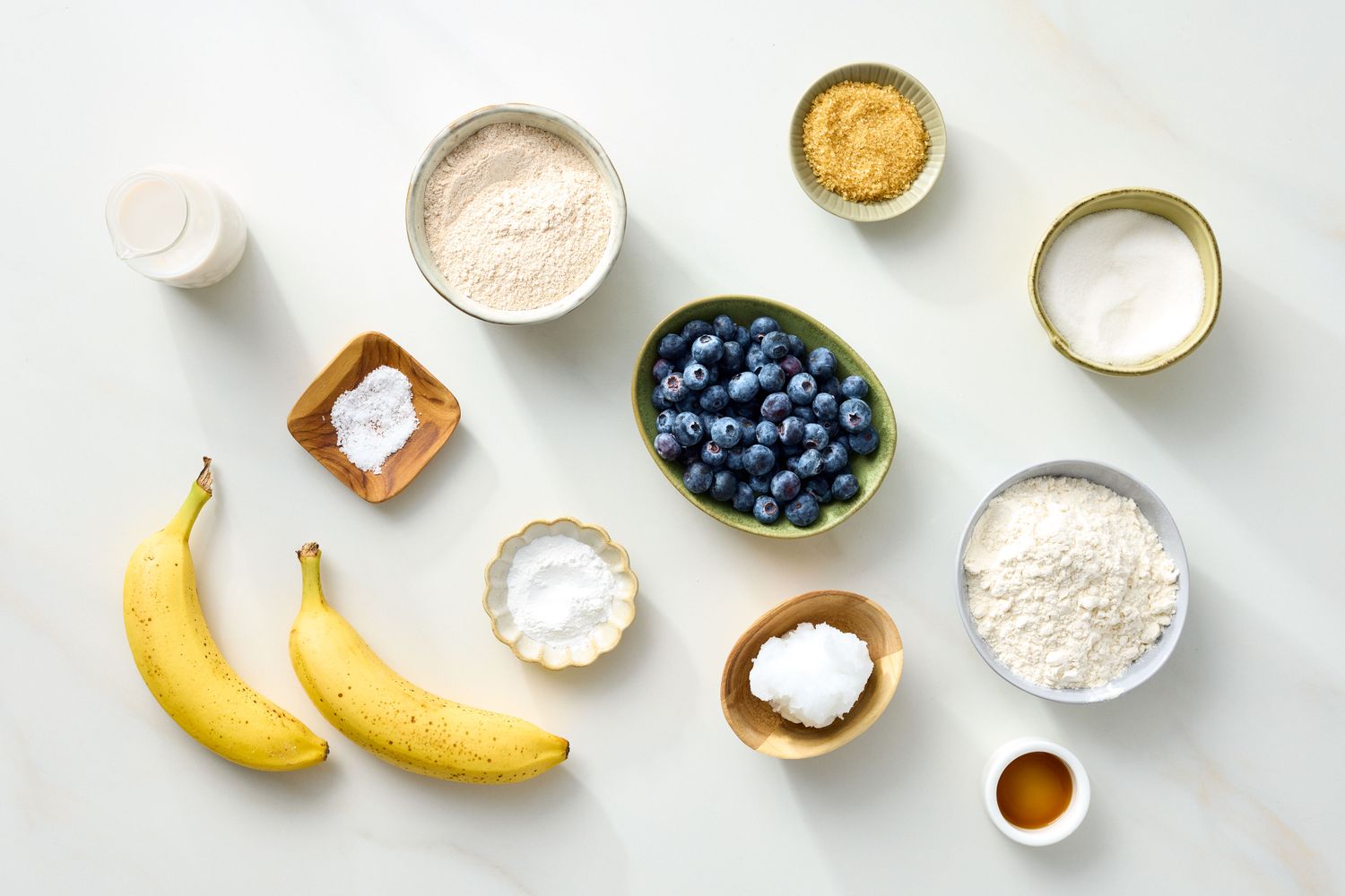 Ingredients for vegan blueberry muffins arranged on a surface