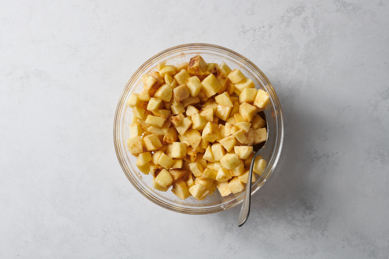 chopped apples mixed with lemon juice and spices in bowl