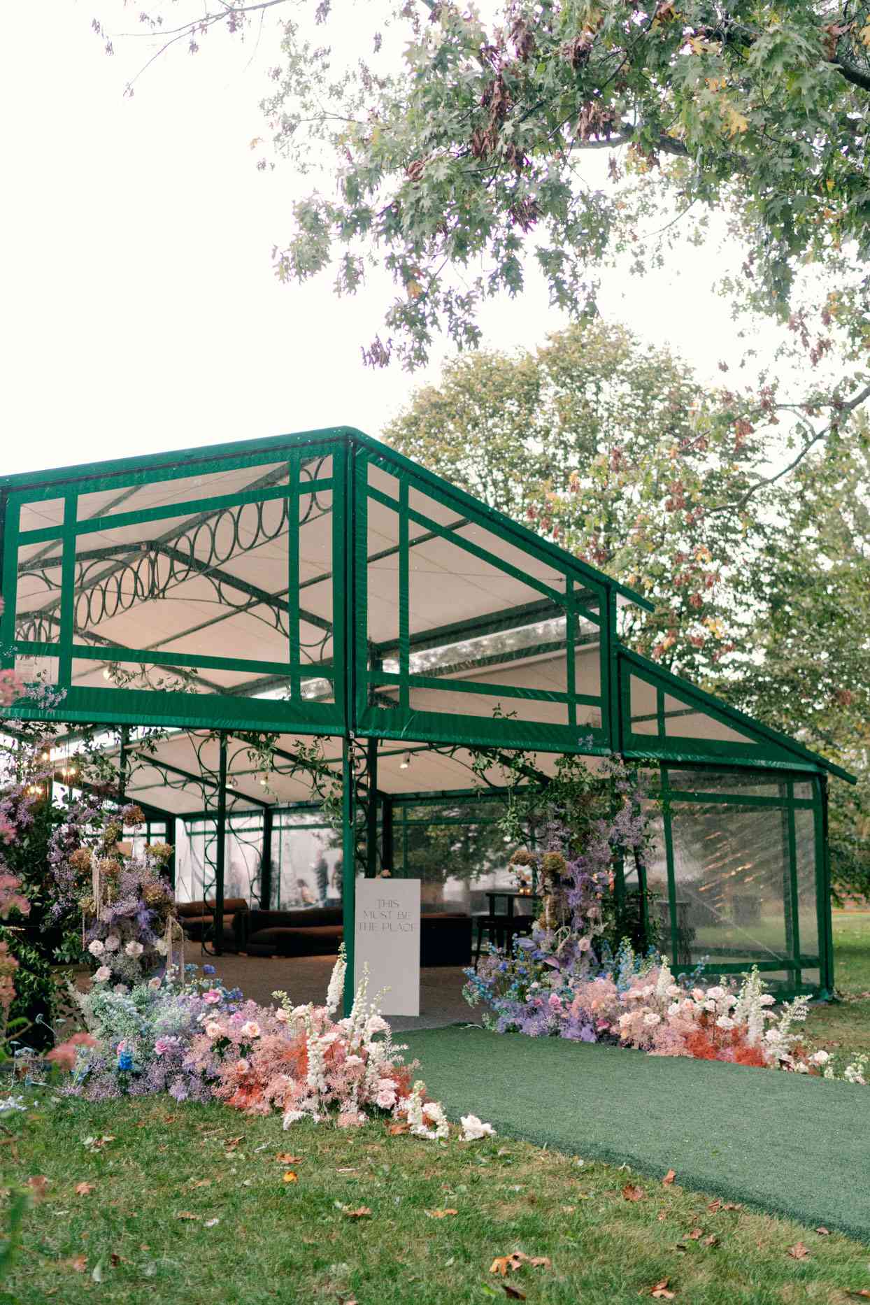 wedding reception tent with floral accented entrance and welcome sign