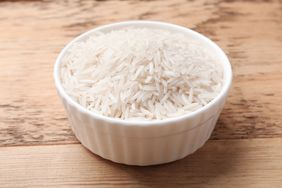 A bowl of rice on a wooden surface