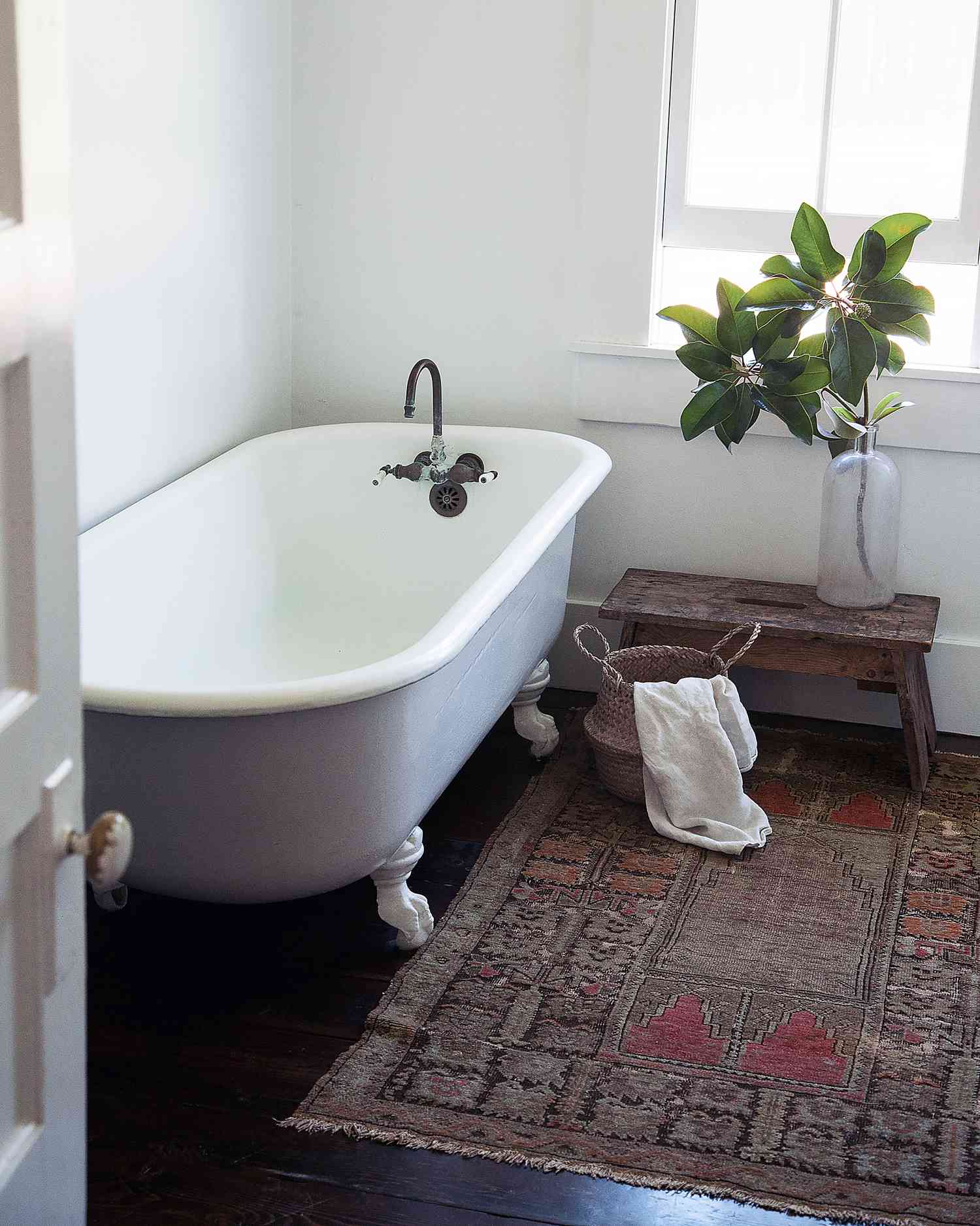 vintage claw foot tub in a bathroom with rug