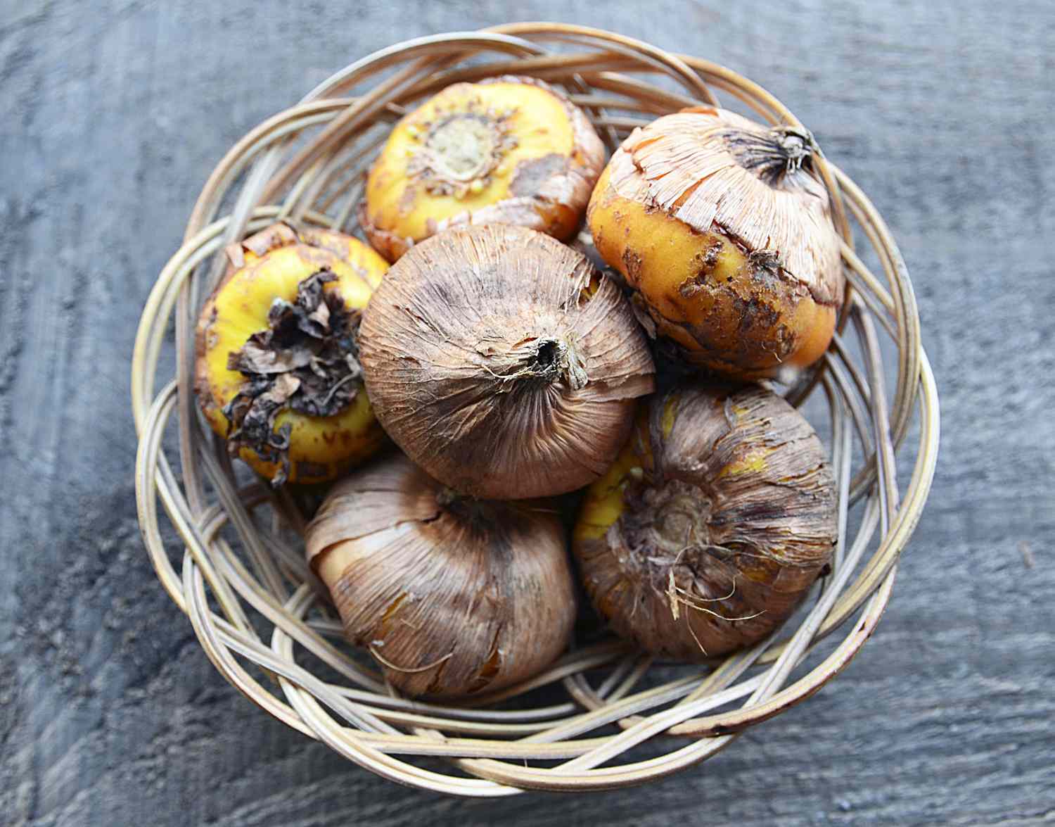 A basket filled with bulbs resting on a textured surface