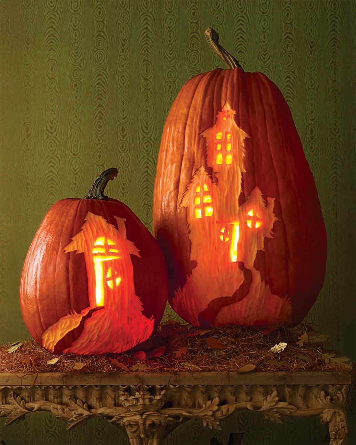 haunted houses carved on tall and short pumpkins