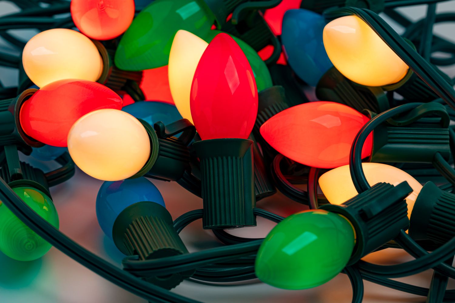A collection of holiday string lights with large bulbs arranged closely together featuring an assortment of colors