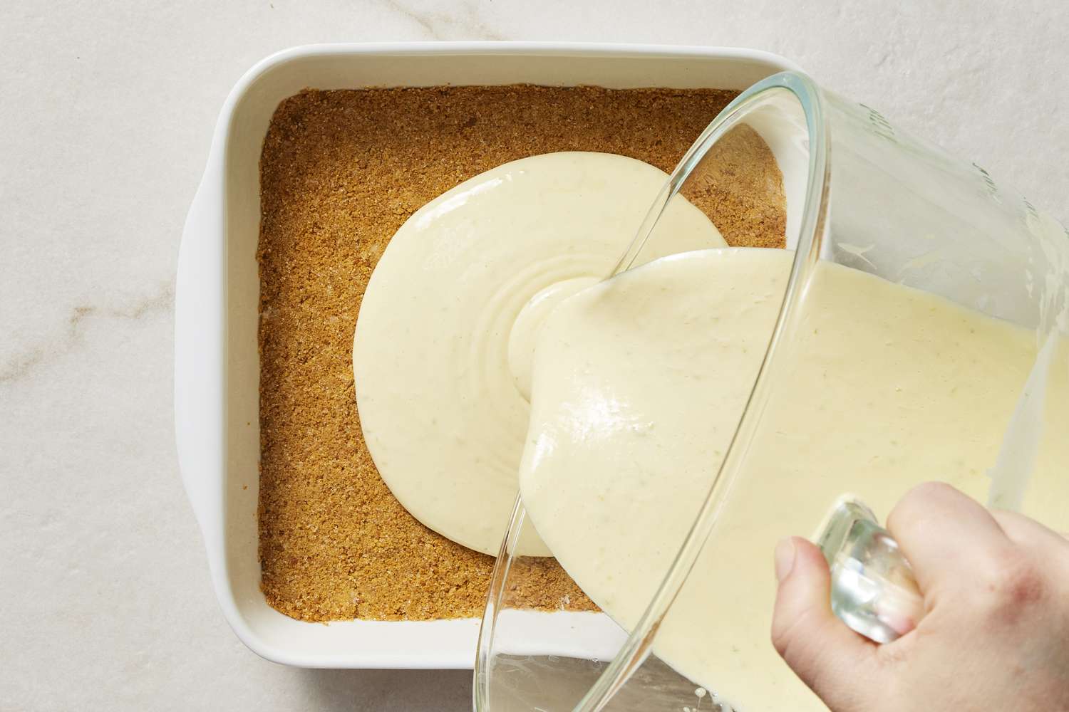 Key lime mixture being poured into pan with crust