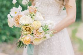 bride holding pastel citrus floral bouquet
