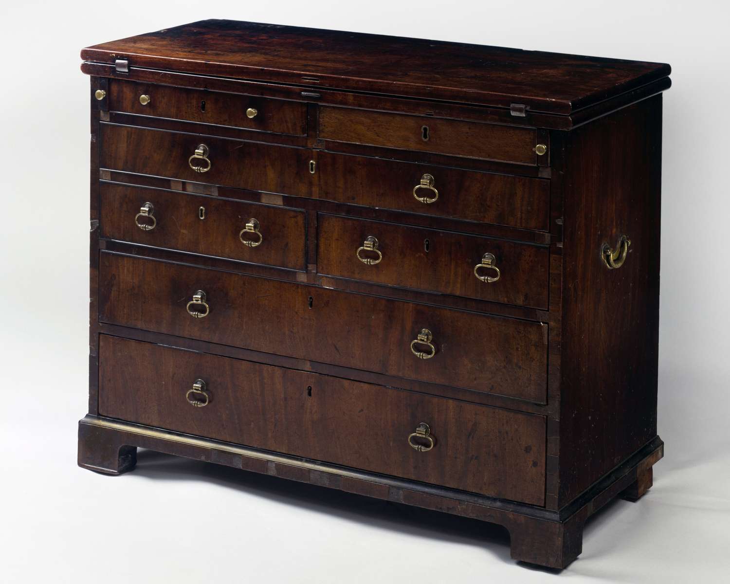 A campaign chest featuring multiple drawers with brass handles and a minimalist design normally used for storage
