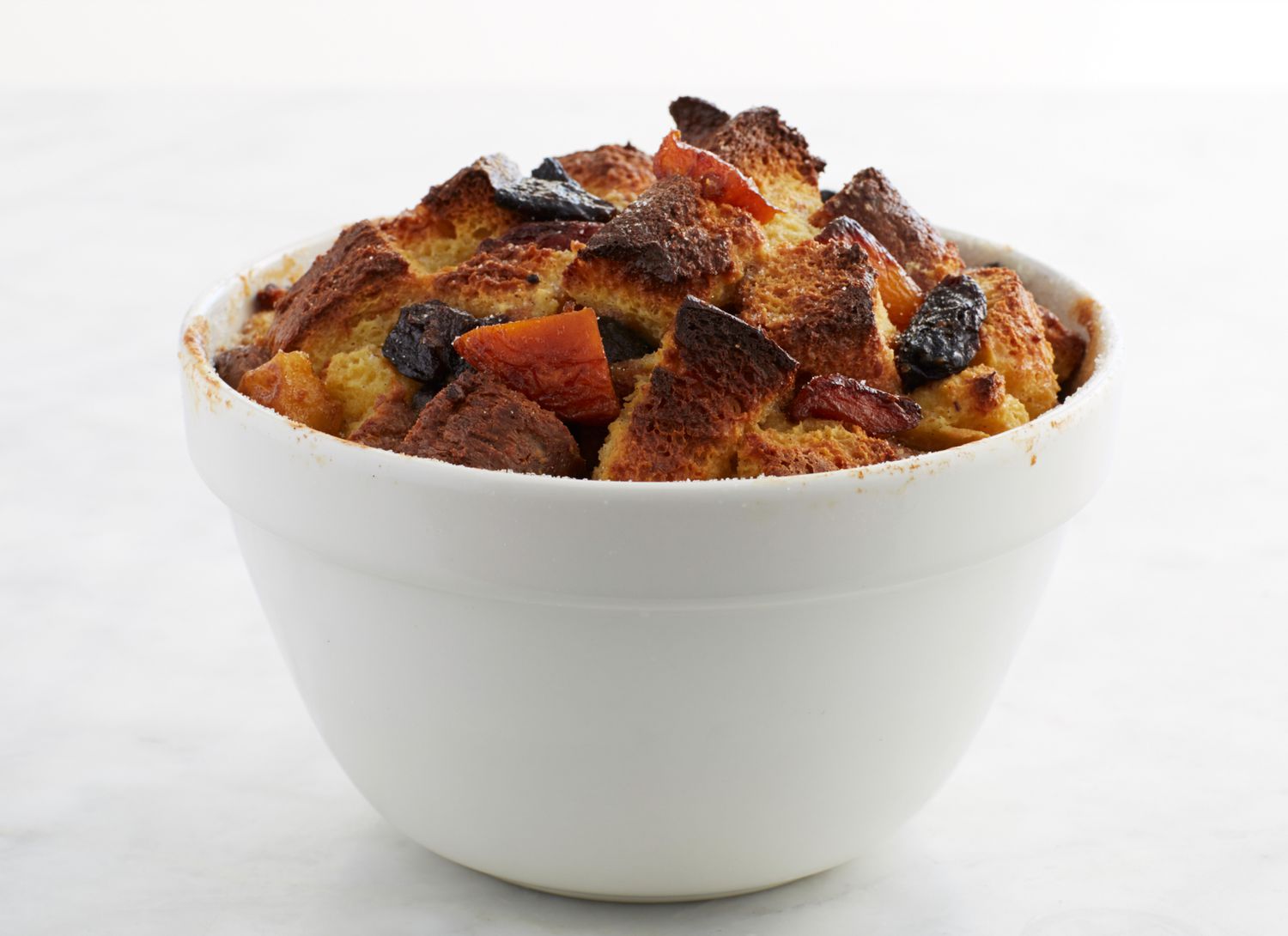 kris kringle bread pudding in a white bowl on white background